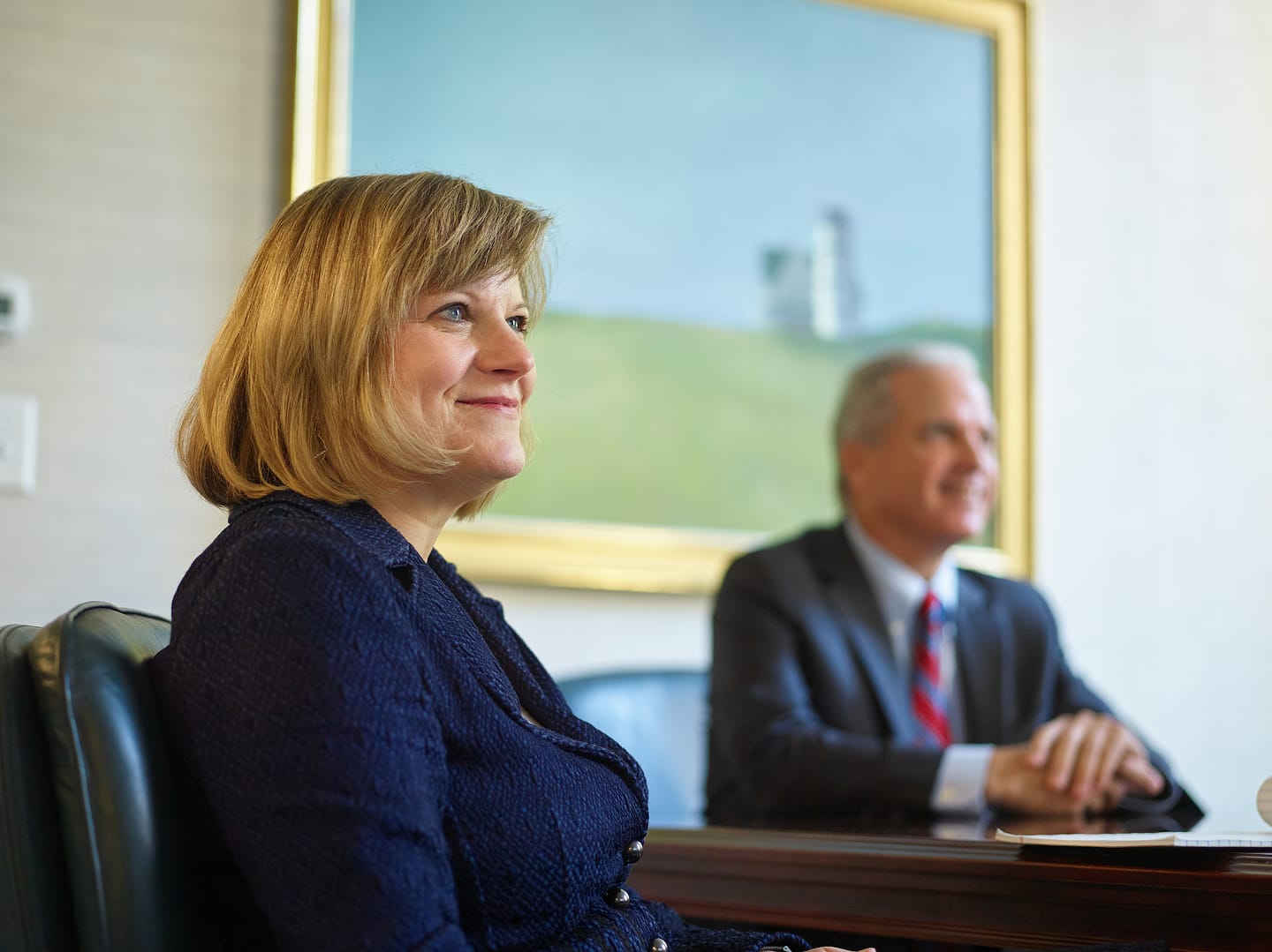People sitting at a desk in an office, smiling